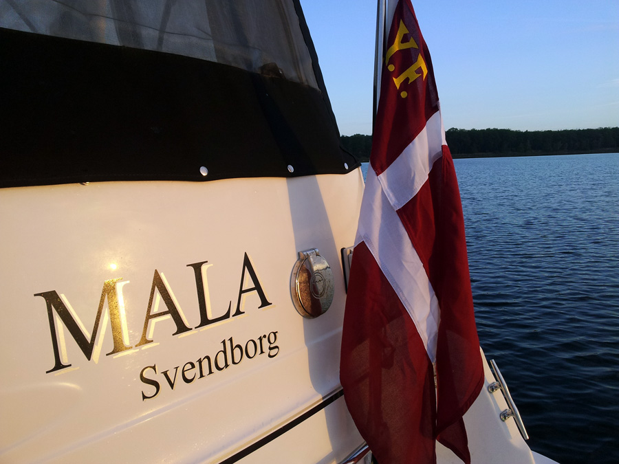 Eksempel på bådnavn i sort med skygge i guld metallic. Båden har fået navnet Mala. På båden ses også havnenavnet Svendborg.
